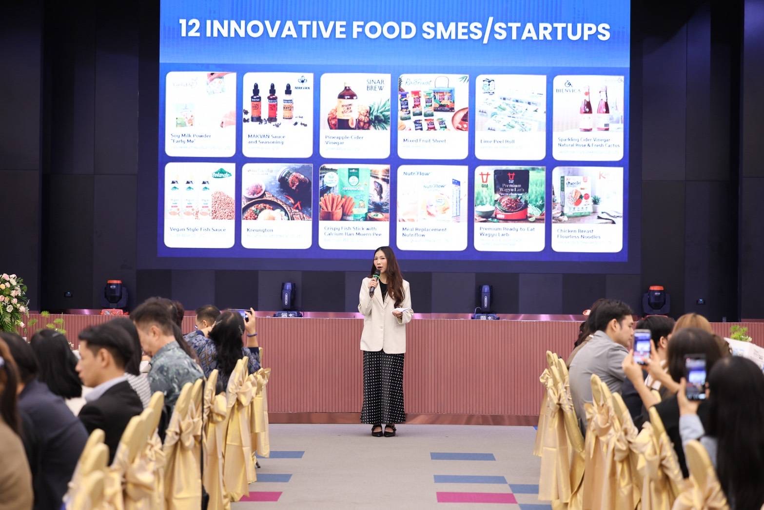 ผู้เข้าร่วมงานพูดคุยธุรกิจที่บูธเครื่องต้น ในกิจกรรม Business Matching